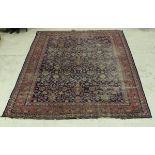 A Persian carpet, the central panel with all over floral decoration on a blue ground,