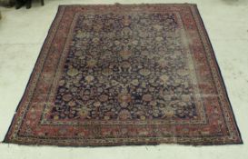 A Persian carpet, the central panel with all over floral decoration on a blue ground,