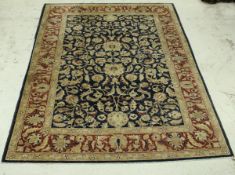 A modern Persian rug, the central panel with all over floral decoration on a blue ground,