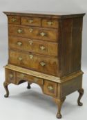 An 18th Century walnut and cross banded chest on stand with three short drawers above three long