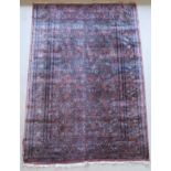 A modern Persian rug, the central panel set with all over floral decoration on a plum ground,