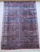 A modern Persian rug, the central panel set with all over floral decoration on a plum ground,