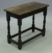 An 18th Century oak side table, the two plank top above a plain frieze,