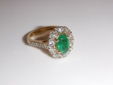 An 18 carat gold, emerald and diamond set ring of cluster form,