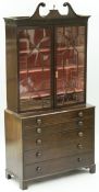 An early 19th Century mahogany secretaire bookcase with swan neck pediment surmounted by a brass