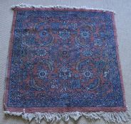 A Persian rug, the central panel set with all over floral decoration on a red ground,