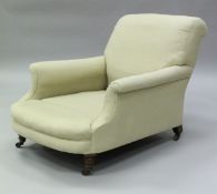 A Victorian Howard armchair on turned front legs to brass castors,