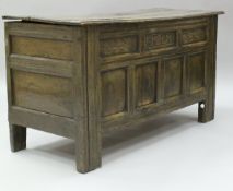 A 17th Century oak coffer, the three plank top with moulded front edge over three slim panels,