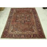 A Persian carpet, the central panel set with stylised star burst medallion on a red ground,