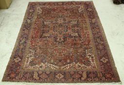 A Persian carpet, the central panel set with stylised star burst medallion on a red ground,
