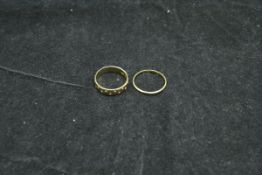 An 18 carat gold wedding band and another 18 carat gold ring,