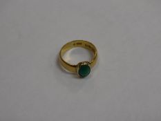 A 22 carat gold ladies dress ring set with an oval cabouchon cut green stone, approx 4.