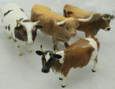 A collection of four Beswick cattle figures including "Ayrshire Bull CH Whitehill Mandate",