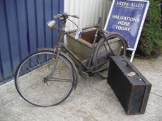 A vintage Raleigh gentleman's bicycle together with a vintage suitcase