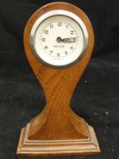 An oak cased balloon clock of small proportions,