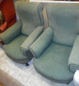 A pair of Victorian armchairs with curved front seats raised on ringed and turned front legs to