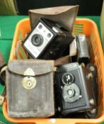 A basket of various vintage cameras including a Coronet Ambassador, a Voigtländer Brillant,