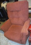 A modern electric reclining armchair in terracotta coloured upholstery