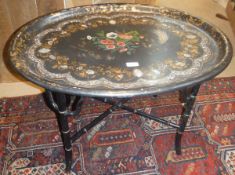 A Victorian black lacquered mother of pearl gilt decorated and painted oval tray top table on