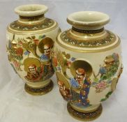 A pair of 20th Century Japanese satsuma ware vases with relief work decoration