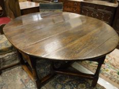 An oak oval gate-leg drop-leaf dining table in the 18th Century manner,