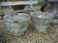 A pair of reconstituted stone garden planters of circular tapered form with grape and floral