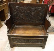 A carved oak box seat monk's bench in the Gothic style