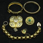 A collection of gold coloured jewellery including a "belt" bracelet, a chain link bracelet,