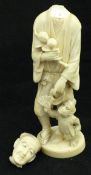 A Japanese Meiji period carved ivory okimono as a man with branch of peaches in his right hand,