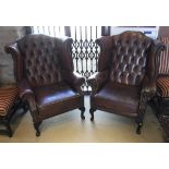 A pair of Georgian style brown leatherette wing back armchairs with cabriole front legs