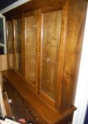 A 20th Century oak display unit with four glazed doors enclosing shelves above a base of three