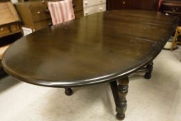 An Ercol Old Colonial dark elm extending dining table