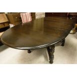 An Ercol Old Colonial dark elm extending dining table