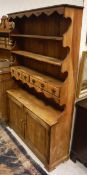 A 20th Century pine dresser with three shelves and two drawers above two cupboard doors