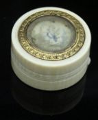 An ivory pill pot with painted decoration to the top set in a yellow metal fioliate band opening to