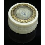 An ivory pill pot with painted decoration to the top set in a yellow metal fioliate band opening to