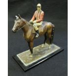 A circa 1900 cold-painted cast metal table lighter / match striker as a mounted jockey in red and