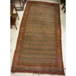 A Turkish rug, the central panel set with repeating stylised floral motifs on a dark blue ground,