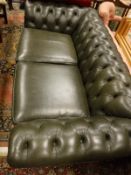 A Thomas Lloyd green leather button back Chesterfield sofa on turned front supports