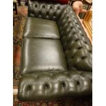 A Thomas Lloyd green leather button back Chesterfield sofa on turned front supports