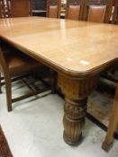 A Victorian oak rectangular extending dining table on foliate carved and reeded baluster supports