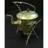 A brass spirit kettle on stand with turned wooden handle on a bobbin decorated X frame to base with