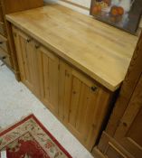 A beech topped kitchen unit over three pine cupboard doors