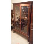 An Edwardian mahogany glazed two door bookcase in the George III taste raised on cabriole legs to