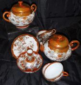 A Japanese satsuma ware part tea wares to include two teapots, twelve teacups and saucers,