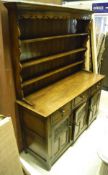An oak Welsh dresser by Rackstraws, with open shelves above three drawers and three cupboard doors,