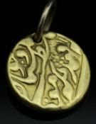 An Eastern yellow metal pendant with script