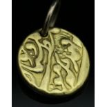 An Eastern yellow metal pendant with script
