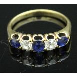 A yellow metal dress ring set with three sapphires and two diamonds, each approx 0.