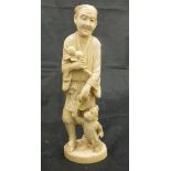 A Japanese Meiji period carved ivory okimono as a man with branch of peaches in his right hand,